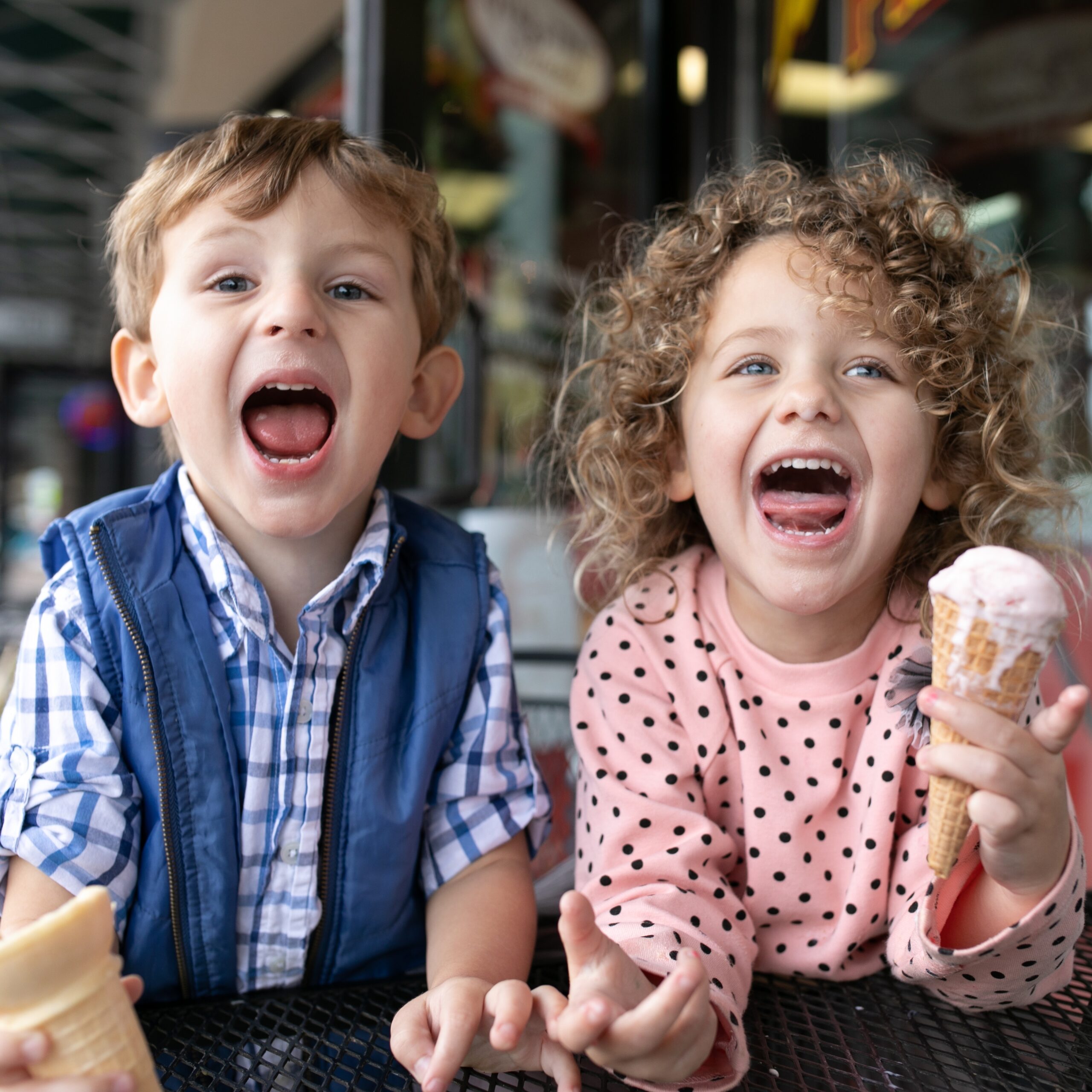 Kids sticking their tongues out and holding ice cream cones