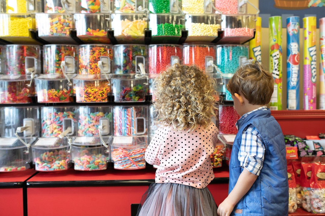 Kids in front of candy wall